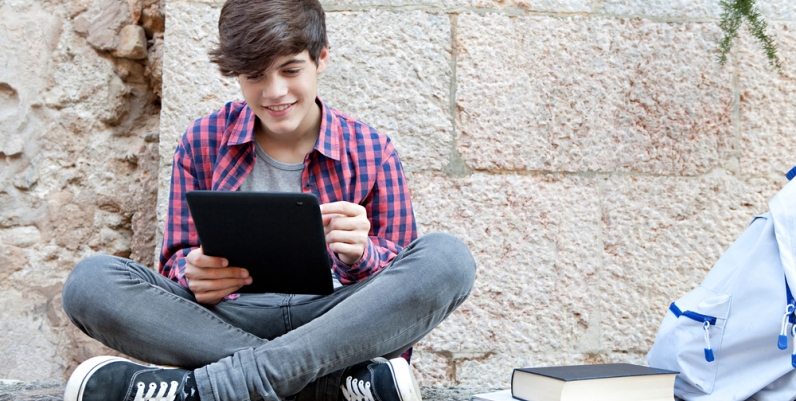 French eBooks Teen boy reading an eBook on a tablet