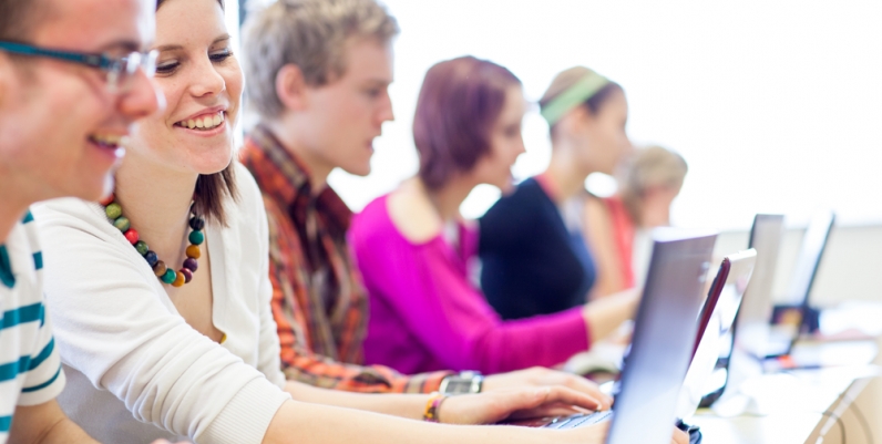 Group of teens sitting at computers