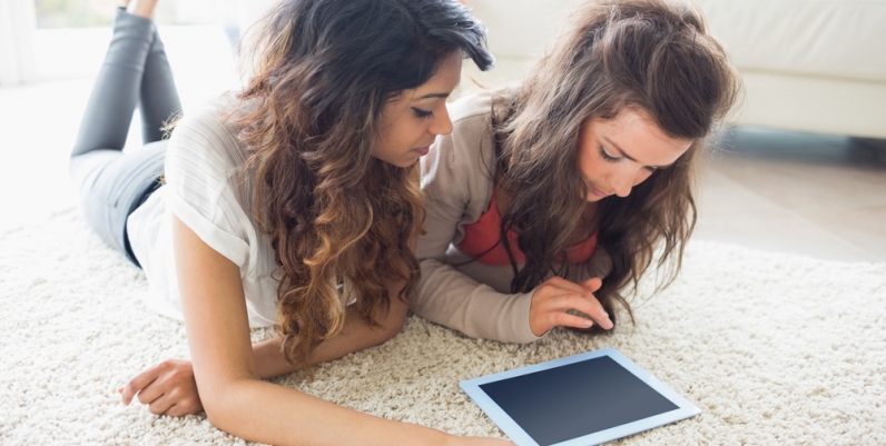 RB Digital Magazines Teen girls reading a magazine on a tablet