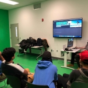 An image of students sitting in the green room at Central Library learning about the software and green screens